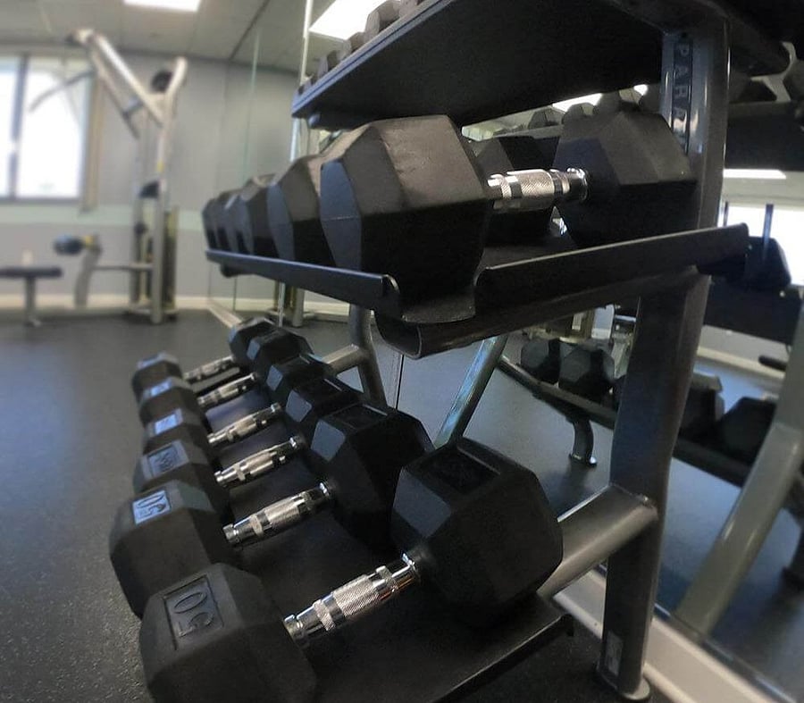 A well equipped exercise room with weights, machines and cardio.