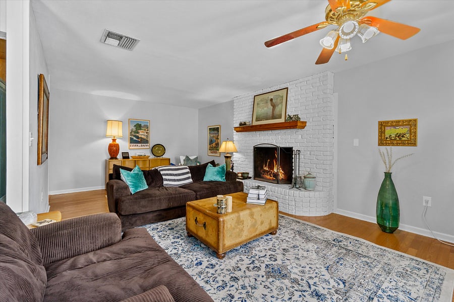 living room with fireplace and extra sheets in the dresser.