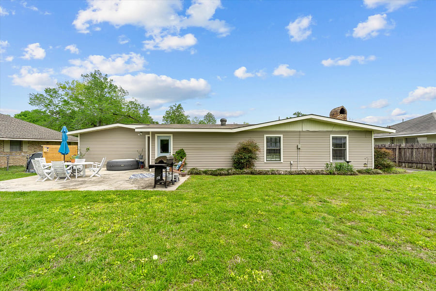 back patio with BBQ grill, cozy hot tub, seating and umbrella.