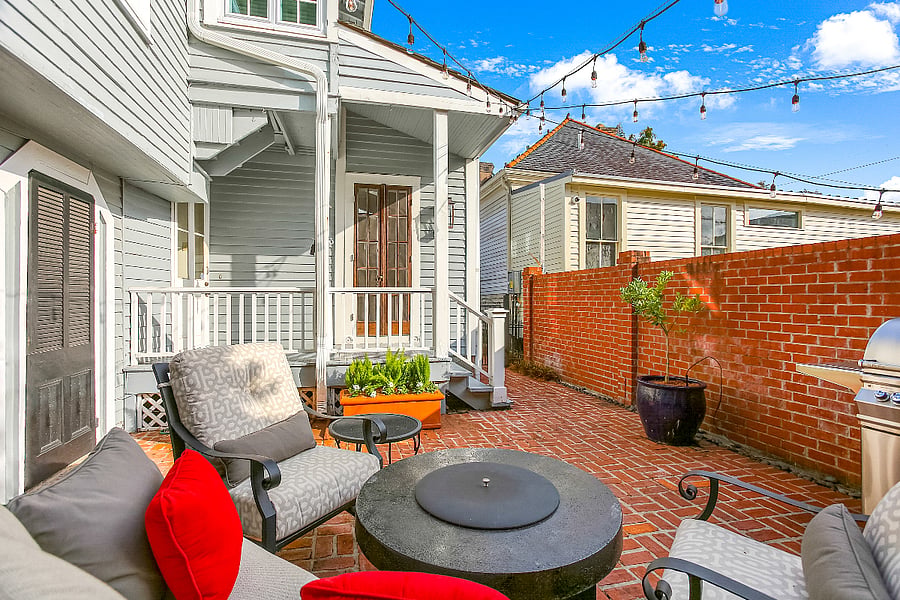 Private brick patio with wrought iron furniture amd deep cushions, offering a relaxing vantage point to enjoy the open sky and quite time outdoors