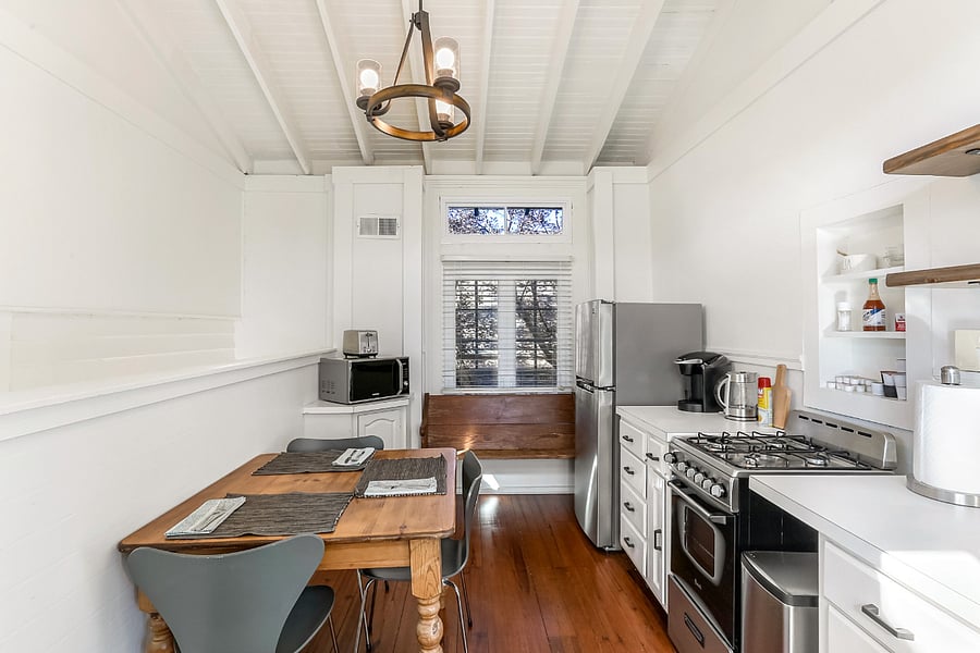 Kitchen of the guest suite with stove, microwave, kettle, toaster, Keurig, and refrigerator/freezer. There are plenty of pots, pans, and other kitchen implements.