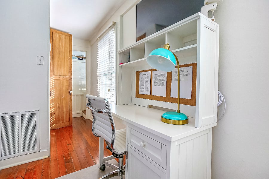 Dedicated workspace with built-in desk, shelving, corkboard, and task lighting. An ergonomic chair, generous surface area, and plentiful natural light make this space ideal for remote work or planning.