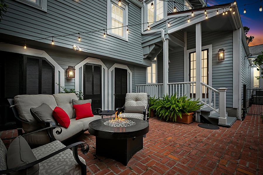 String lights and a fire pit create a cozy settling for relaxing or stargazing on the brick patio after dark