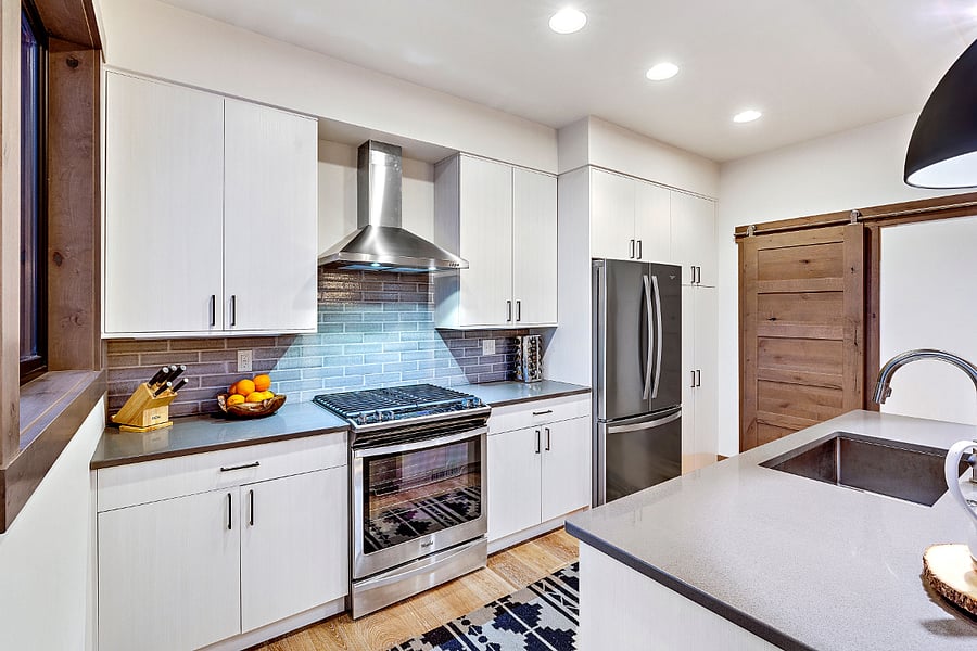 Open plan kitchen. The laundry room and pantry area are behind the sliding wooden door.