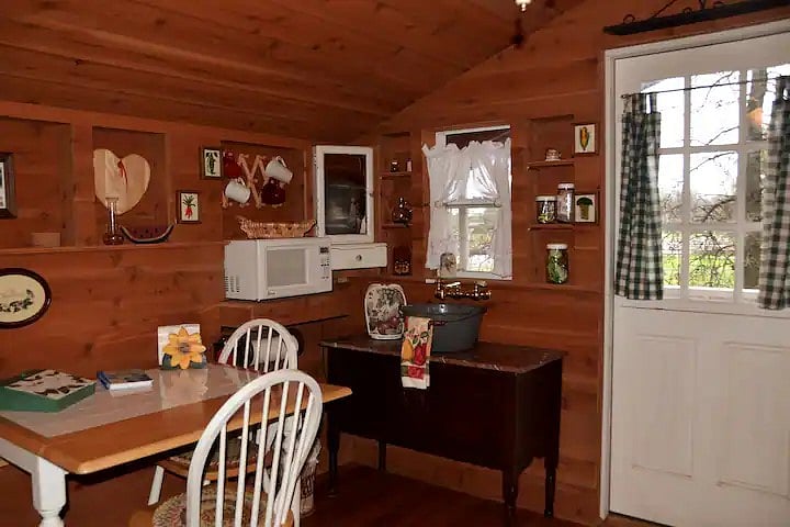 Dining & Kitchenette to left of Dutch door to porch & pasture. Microwave, coffee maker, sink, cabinet & cutlery drawer. Side board contains dishes, cooking ware, toaster, water filter pitcher, hot pot & electric skillet.