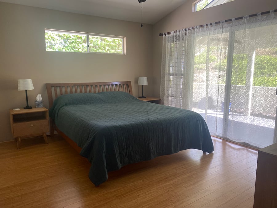 Main bedroom with California King bed, en suite bathroom, air conditioning, and direct lanai access.