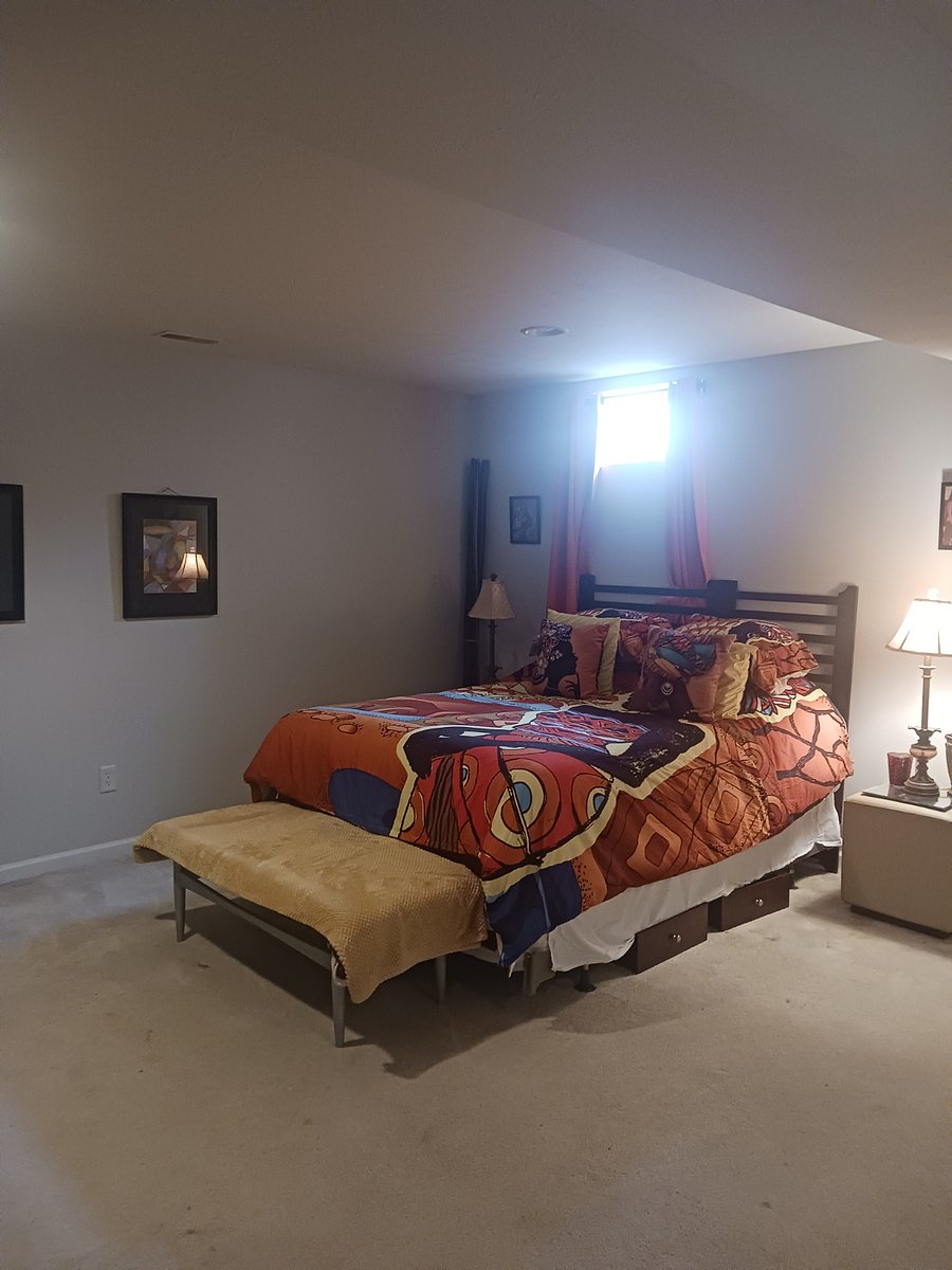 Queen size bed, under bed storage, bedside tables with lamps, and other decor.