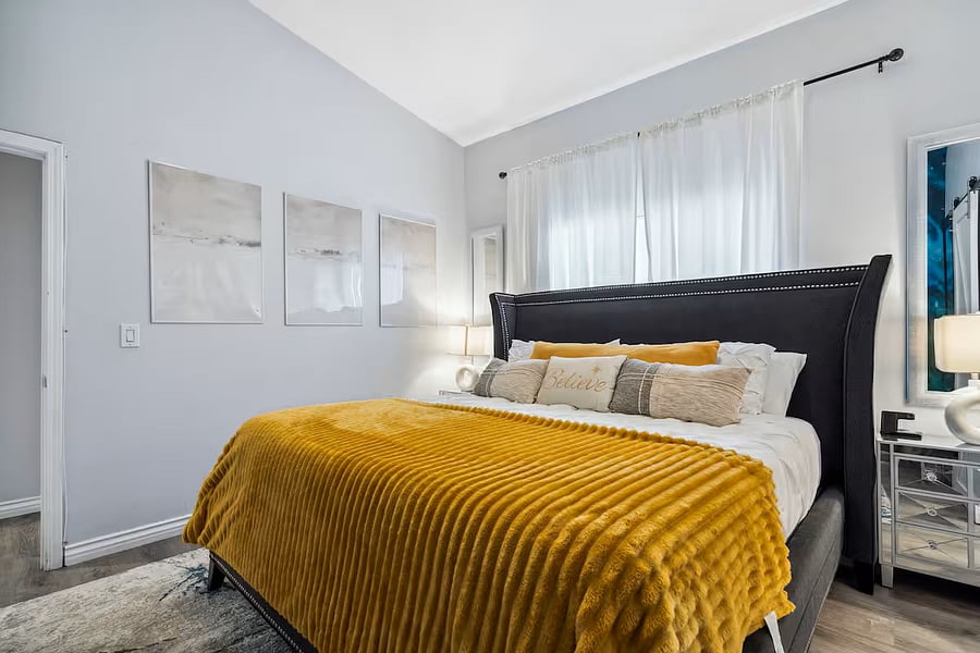 Recharge in luxury, this serene bedroom features soft textures, high ceilings, and a cozy king bed dressed to impress