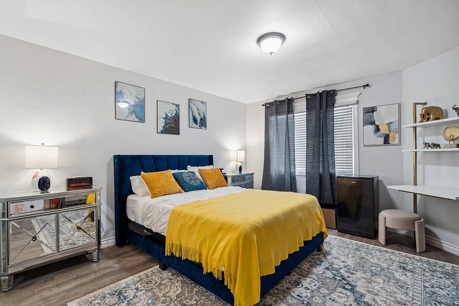Wake up to natural light in this stylish, cozy bedroom with blackout curtains and workspace.