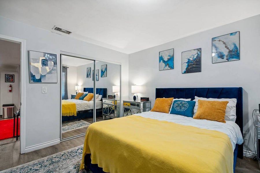 Modern art, mirrored closets, and a bold color palette make this room feel fresh and inviting.
