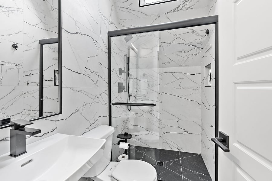 Fully tiled floor to ceiling bathroom with sky light.