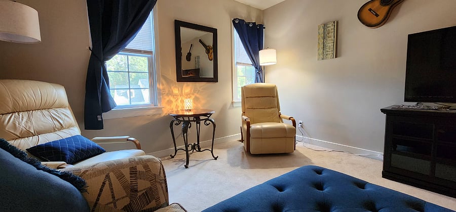 There is a large loveseat style chair and 2 leather rocker recliners. This space is a flex-space and is currently being used by the guests upstairs. It helps to promote some space between guests.