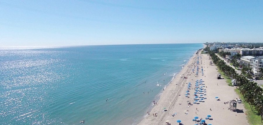 Soak up the vibrant energy of South Florida's iconic Gold Coast  just 4 miles from your Hidden Woods of Deer Creek vacation rental in Deerfield Beach FL, this stunning 
aerial view captures the beautiful sandy shores, colorful beach umbrellas, and crystal clear waters that make this stretch of coastline one of the most sought after beach 
destinations in all of South Florida.
