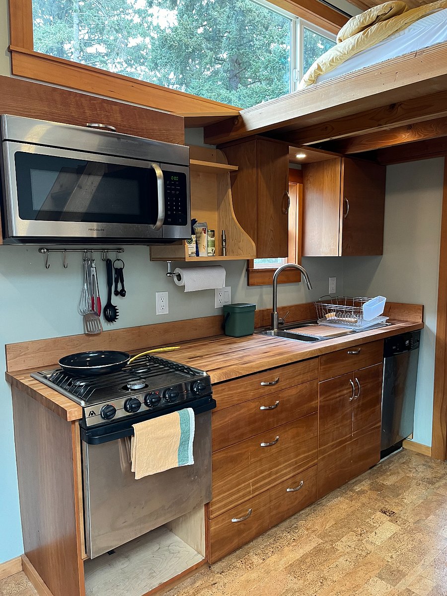 Kitchen with microwave, gas range, sink, dishwasher and view of the garden and beyond.