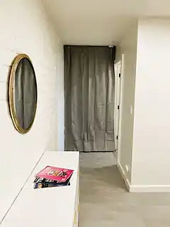 Bedroom hall, bathroom is to the right. Door behind this curtain is deadbolted and connects to main house. Not accessible by guests. Only accessible by owners/property manager 