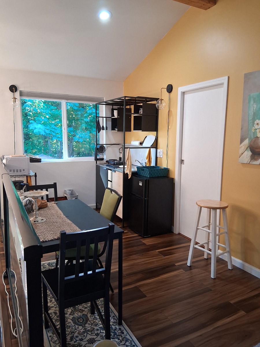 The bright kitchen looks out to abundant greenery. A kitchen table that doubles as a desk with floor electrical outlets