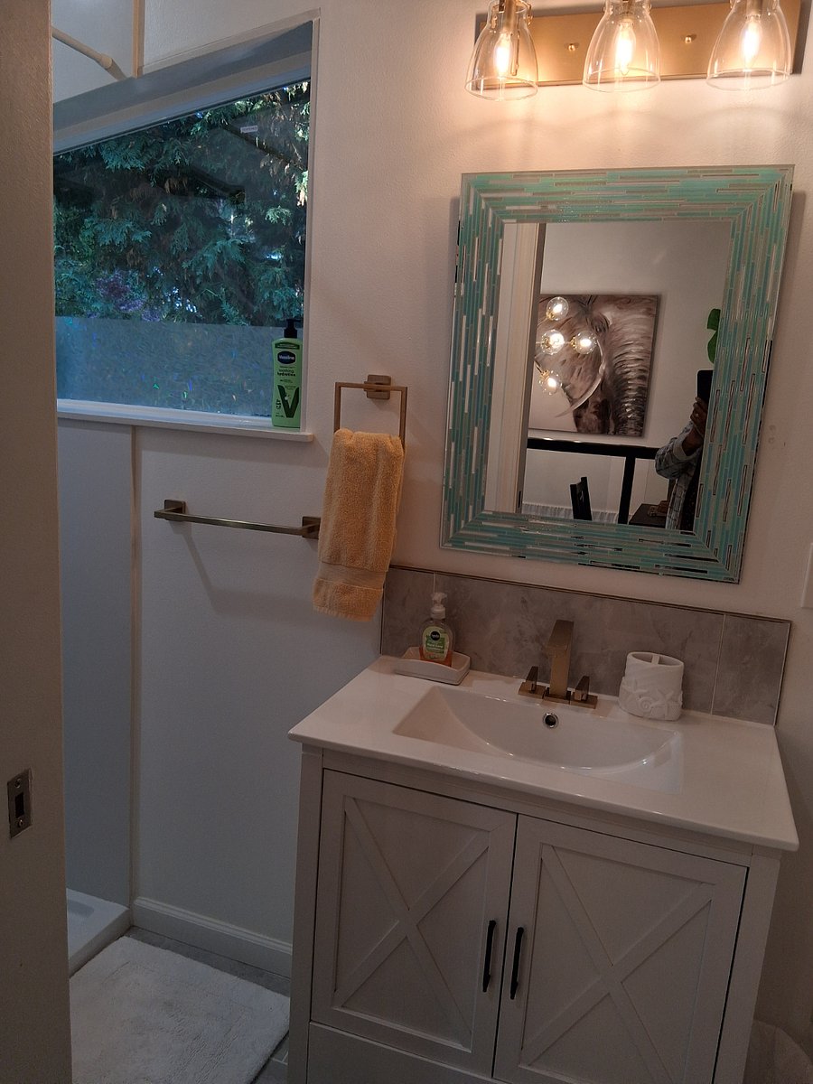 Gorgeous bathroom with beamed ceiling 2 big windows allow you to shower in the Evergreen trees outside them. Art-filled walls, 12' ceiling.