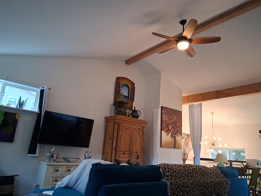 Large ceiling fan on beamed double height ceiling.