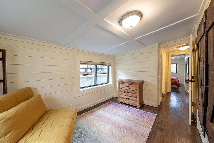 View across the hall shows the cottage's efficient layout, with both bedrooms and the bathroom just steps apart.