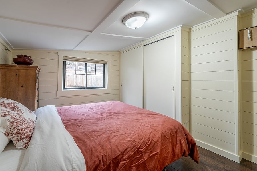 Cozy queen bedroom with built-in storage and thoughtfully arranged space.