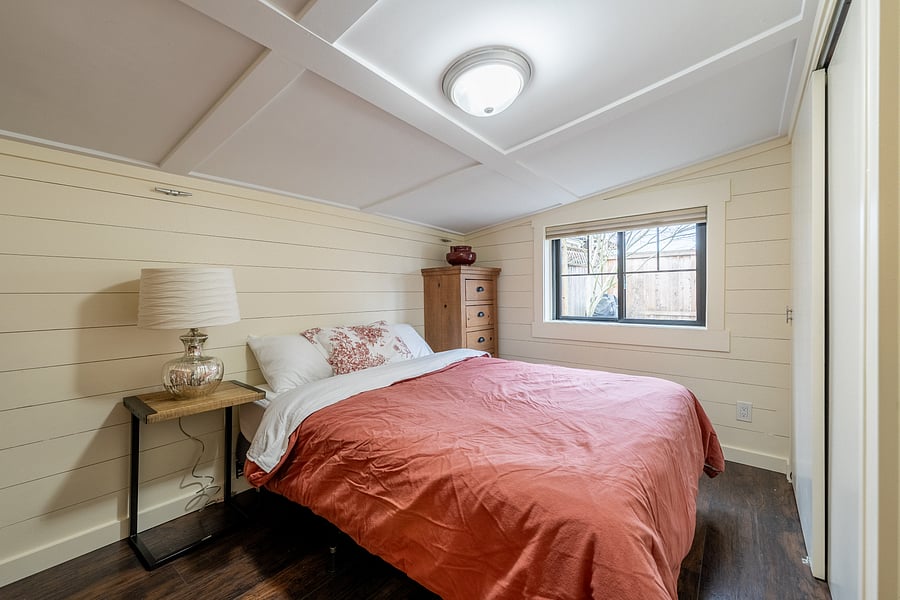 Primary bedroom overlooks the private fenced yard and mature greenery-a wonderfully peaceful setting with the windows open.