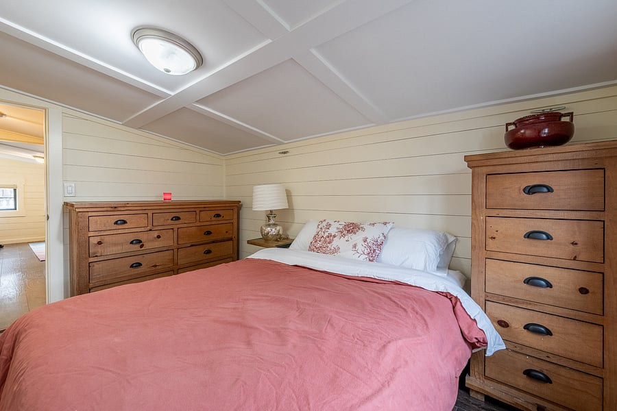 Cozy queen bedroom with built-in storage and thoughtfully arranged space.