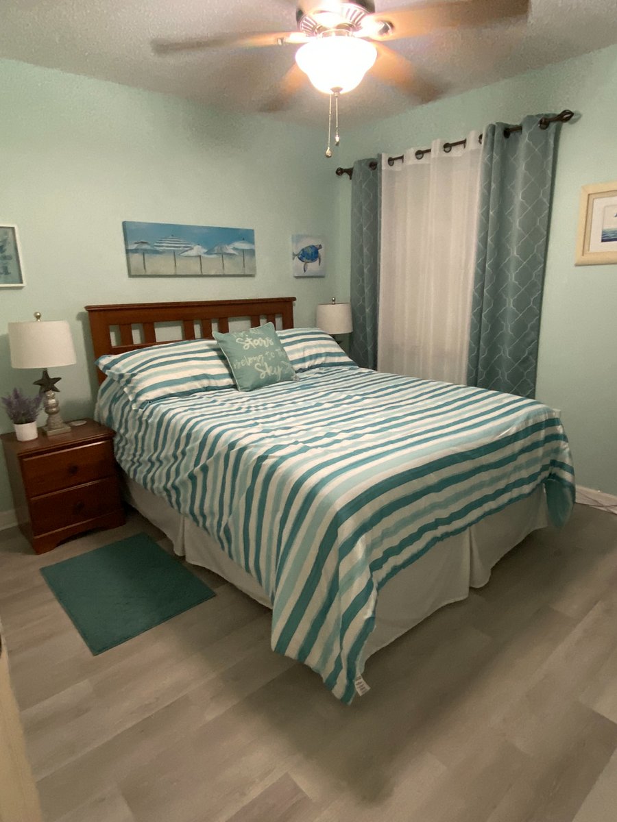Queen size bed in guest bedroom with two nightstands .