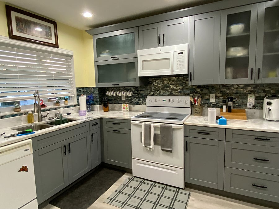 Additional Kitchen view, showing over the stove microwave, stove, refrigerator, and air fryer on counter.