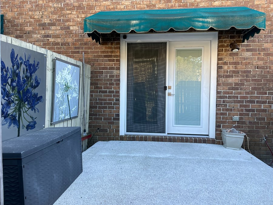 The exterior entrance at the parking lot is considered the back door, but is the main entry way. It features a french door and double screens. The art on the exterior is made by the owner and is permantely installed for outdoor enjoyment.