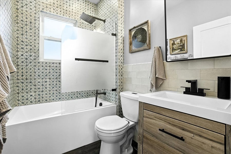 Full bathroom with tub, rain shower head and handheld sprayer, sink/vanity, good lighting, fun tile