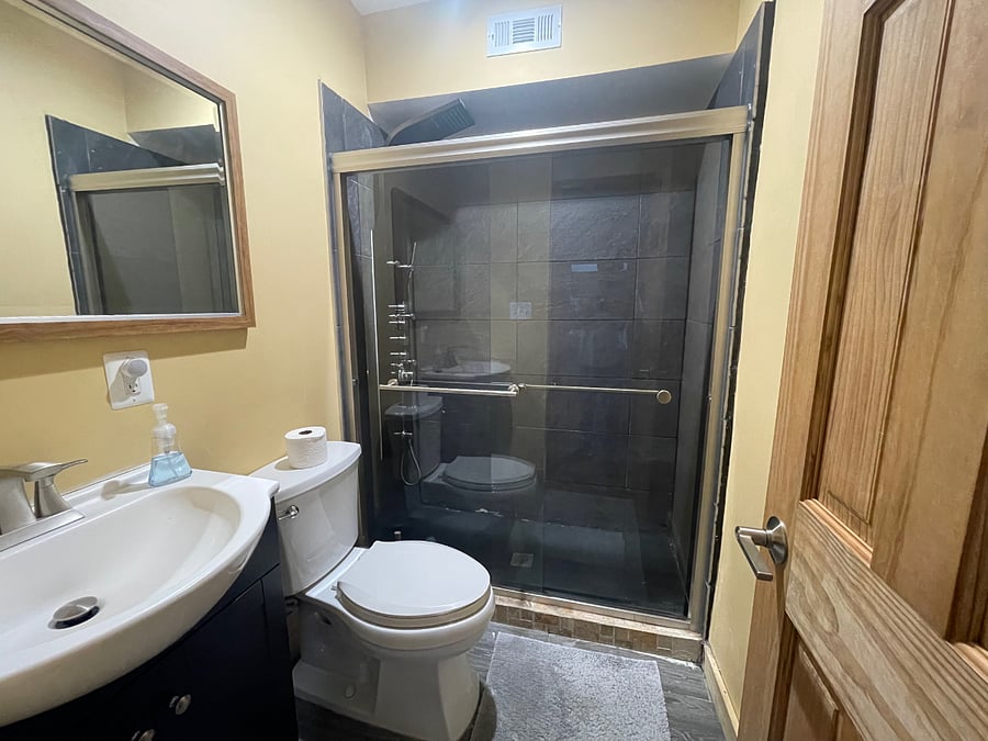 Private bath features versatile shower with waterfall and body spray settings. 