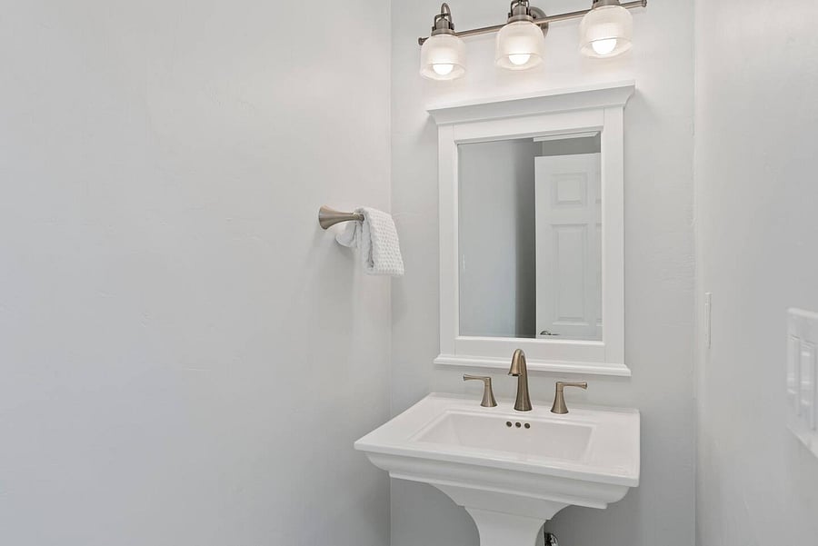 Bright, modern bathroom with a spacious vanity, large mirror, stylish fixtures, and convenient towel storage.