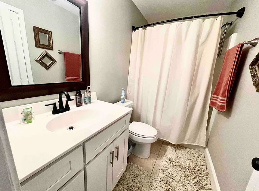 Hallway bathroom with shower tub combo with linen closet