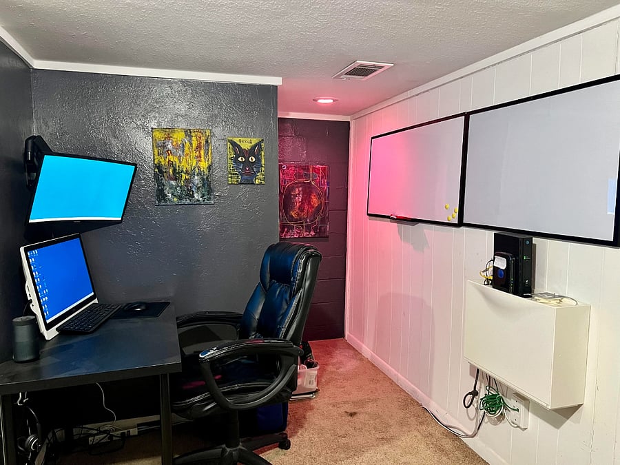 Downstairs work area with desk, wall monitor, two white boards and Wifi