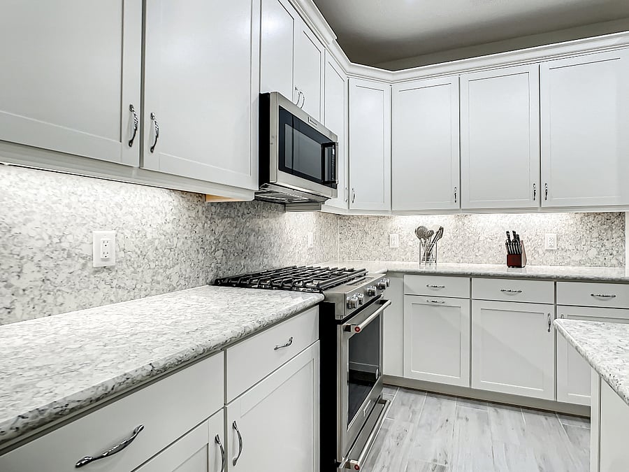Kitchenaid microwave and gas stove/oven. Quartz countertops and backsplash.