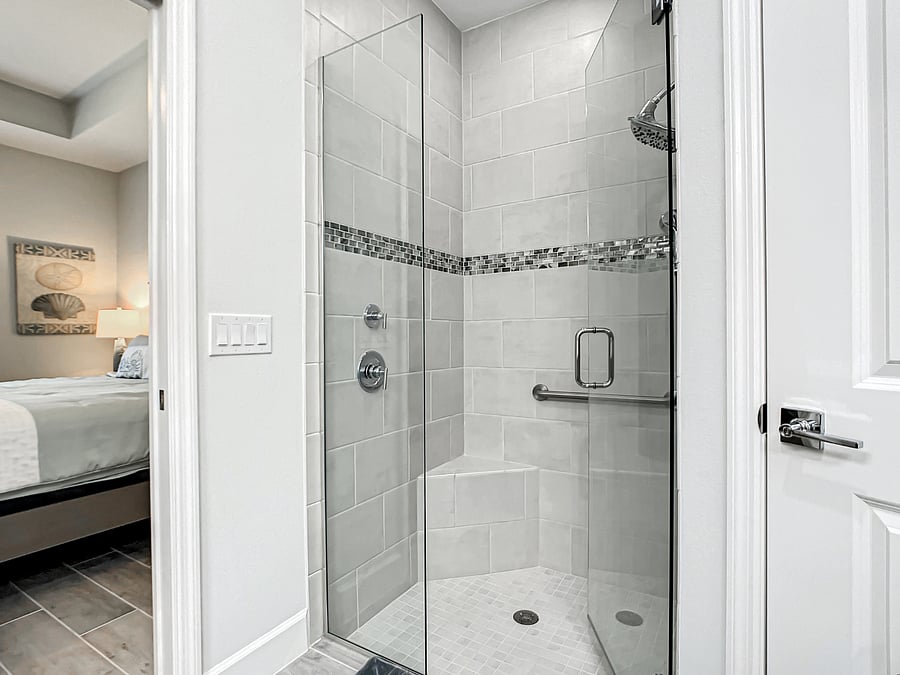 Owner's Suite tile shower with frameless glass shower enclosure.