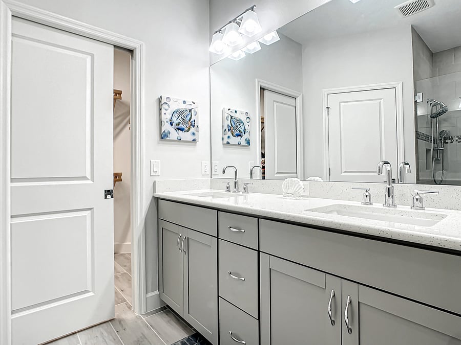 Owner's Suite bathroom with quartz countertops and double sinks. Walk-in closet has pocket door.