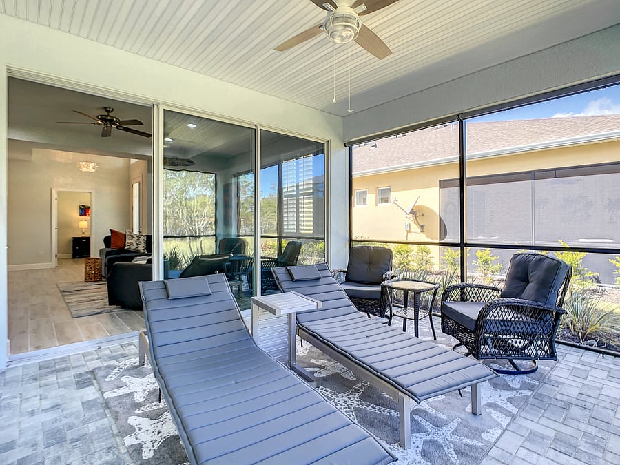 Double-sliding glass doors open up the screened-in lanai as additional living space.