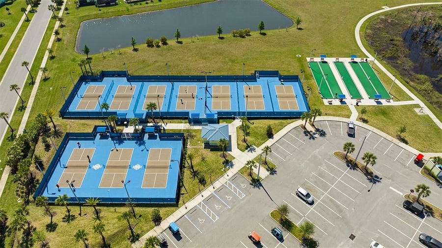 Aerial view of outdoor lighted pickleball and bocce ball courts.