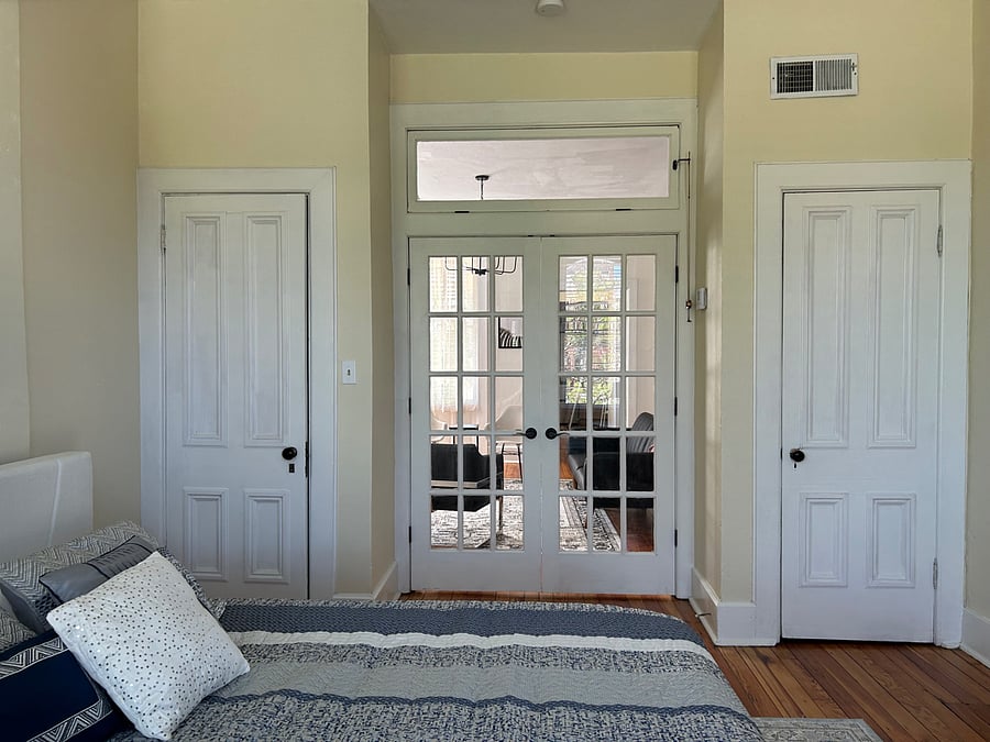 French doors in bedroom flanked by 2 closets