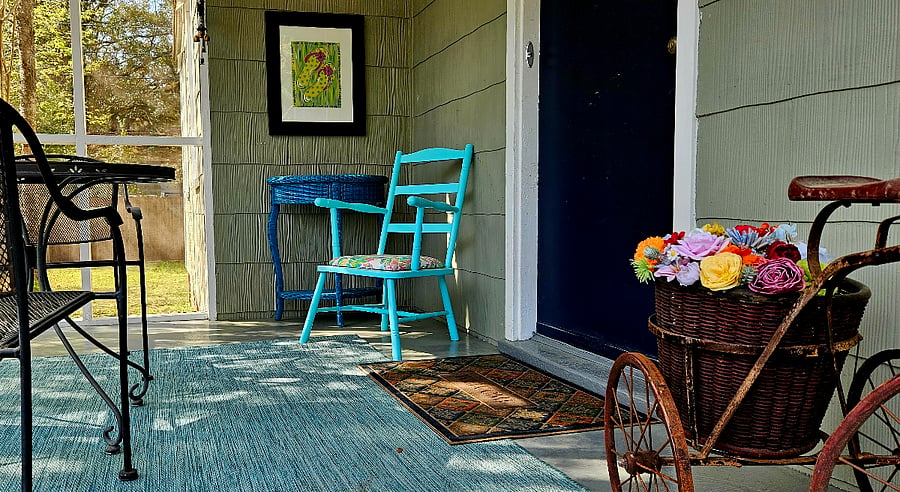 Screened in front porch with breakfast table and chairs