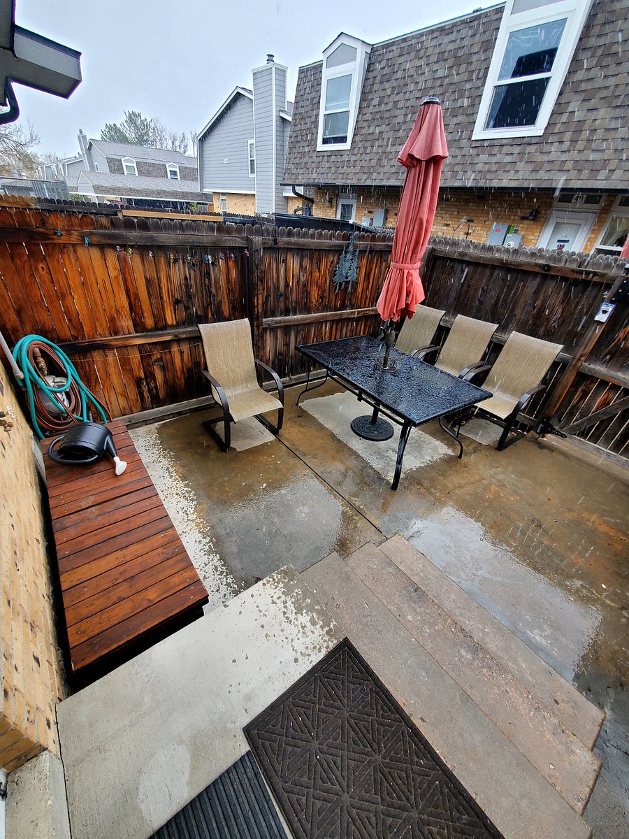 Back patio with large table and umbrella. 