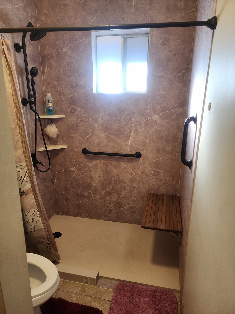 Shower with two head shower,  two ADA grab bars, and fold down seat.