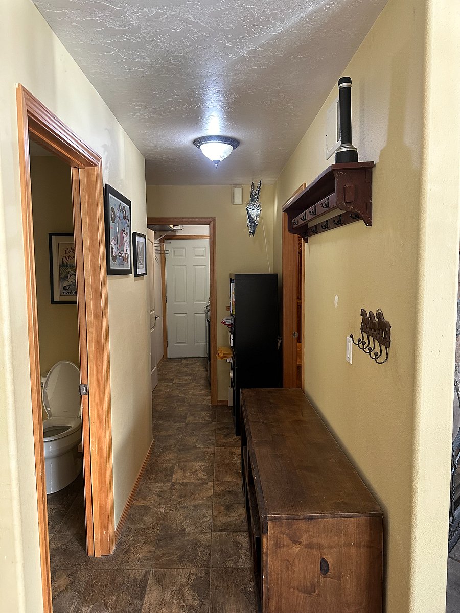View upon entering the froont door. Lots of hooks for coats. Gear storage shelves below. Laundry room at end of hall, bathroom on left.