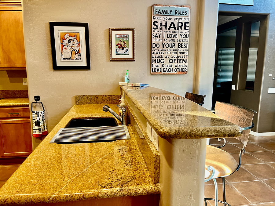 Kitchen sink with breakfast bar leading to living room