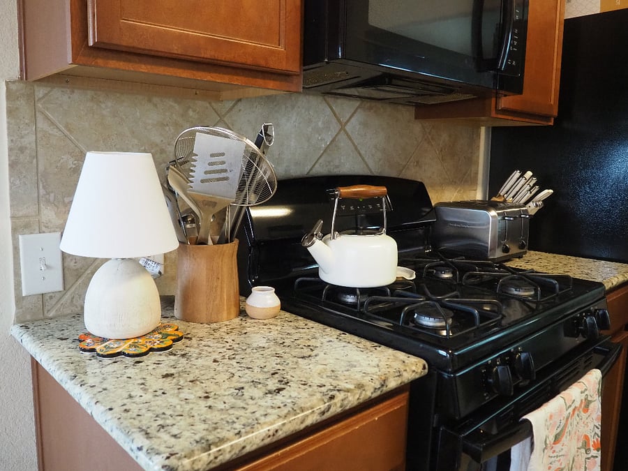 Gas stove and oven, microwave, tea kettle, and toaster.