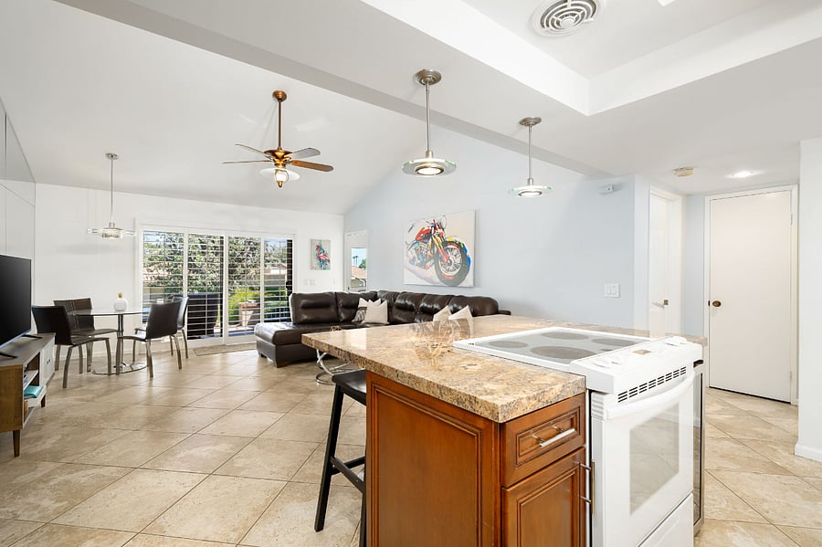 Island cooktop opens to living room and views of the mountains and grassy green belt