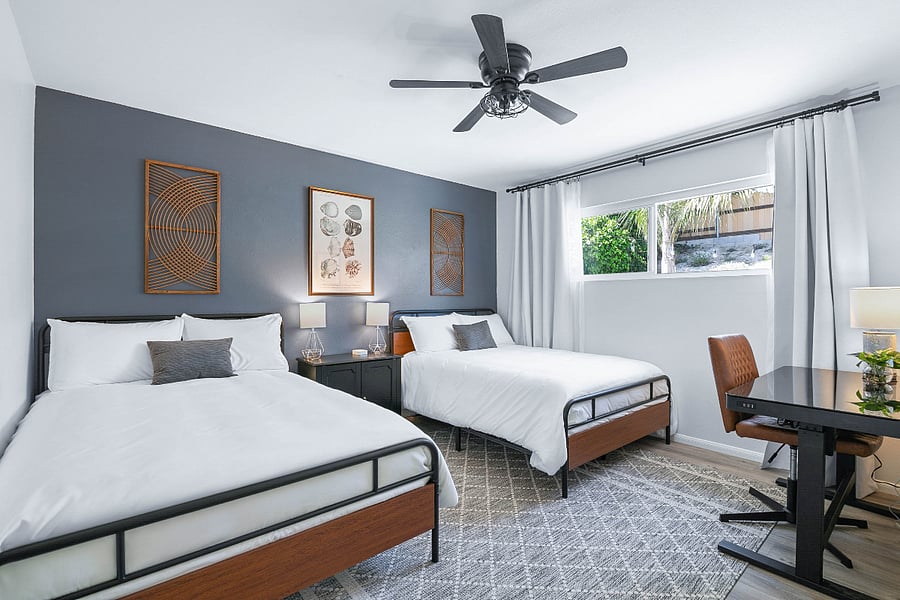 Bedroom 2 include two full sized, plush beds. Blackout curtains, charging dock, two luggage racks, and dedicated workspace also provided.