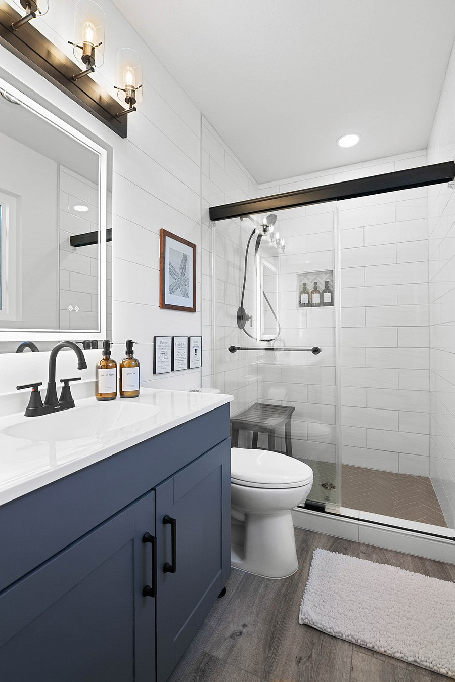 Master bathroom featuring walk-in shower with shower bench. Amazing shower experience with wide shower, strong water pressure, and detachable shower head. Bathroom includes a lighted mirror with multiple light temperature settings.