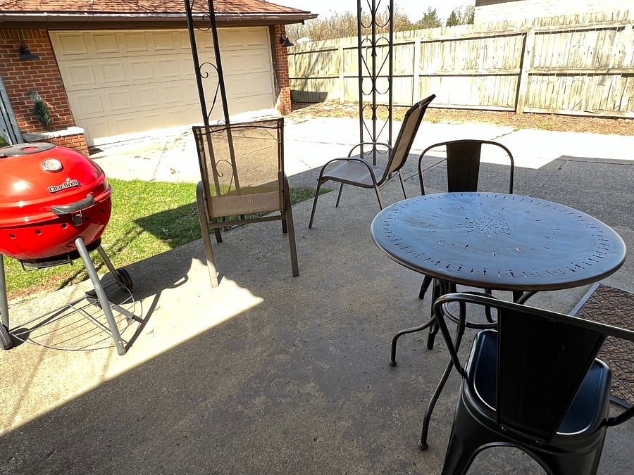 Covered patio off of the dining area with outdoor seating and grill